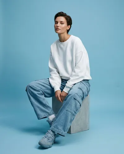 A futuristic fashion editorial photograph of a woman seated in an elegant relaxed posture within a clean minimalist studio environment,...